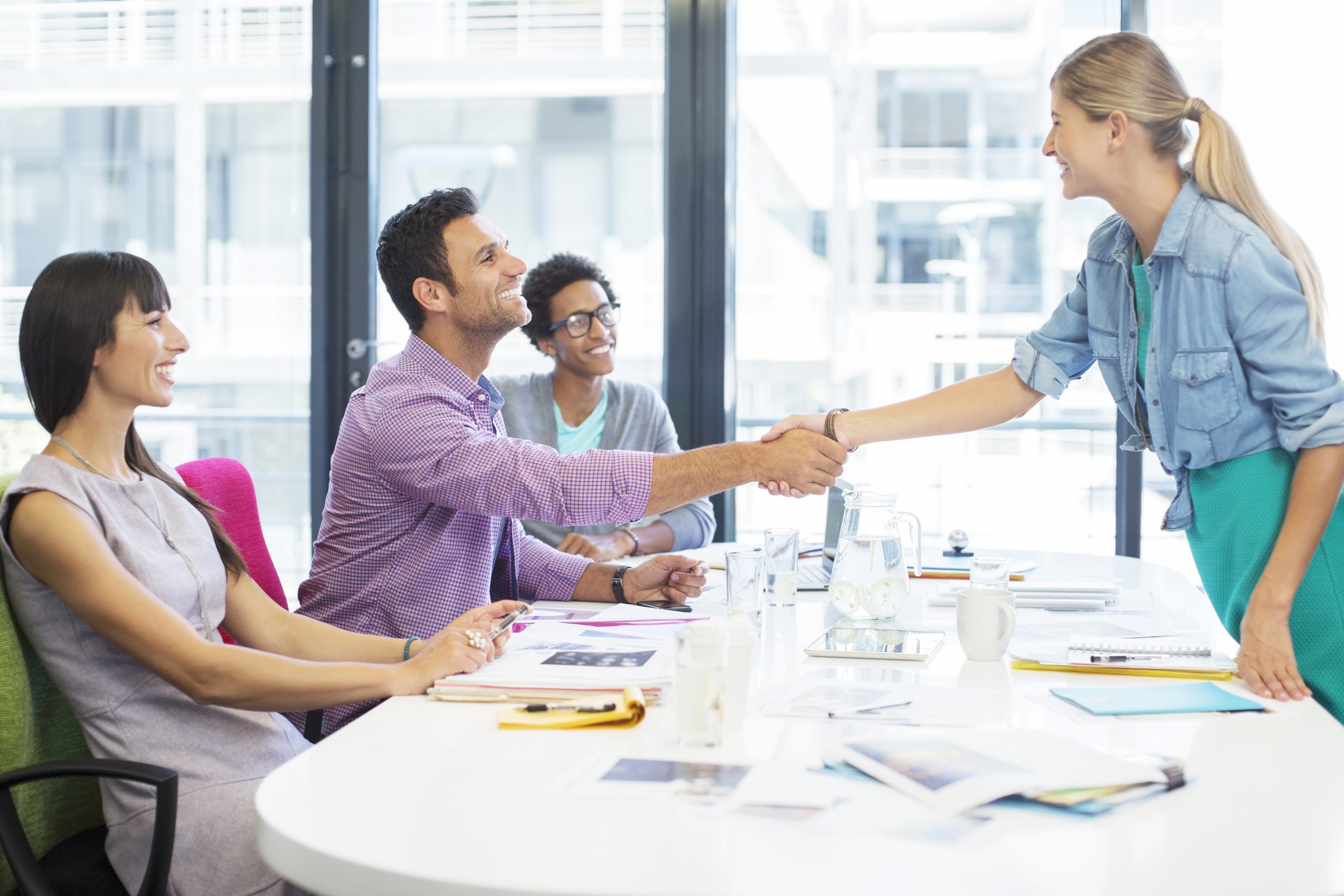 Depiction of businesspeople shaking hands in a meeting