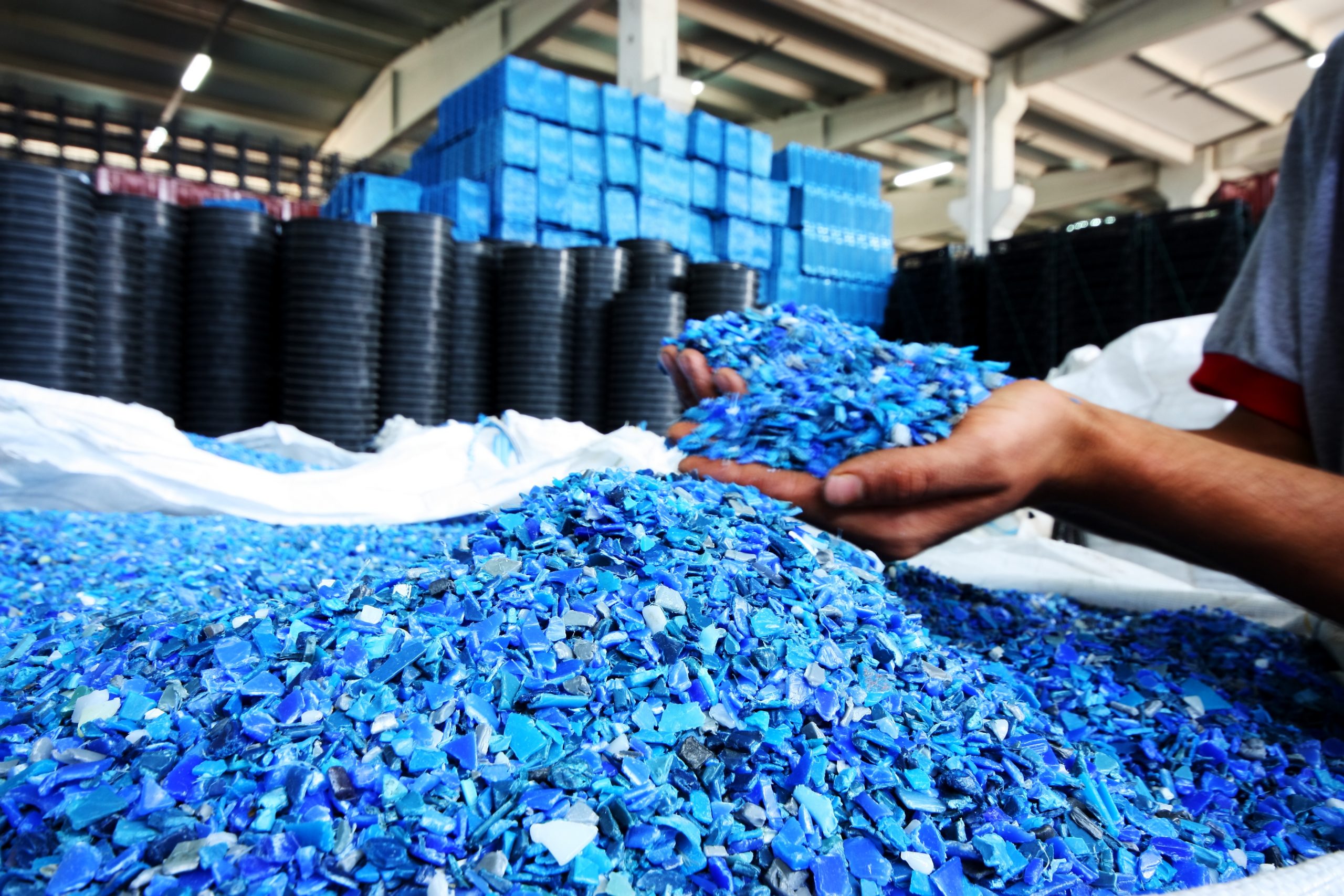 Depicts Plastic Resin pellets being held in a worker's cupped hands.